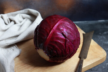 Organic purple cabbage on wooden cutting board.