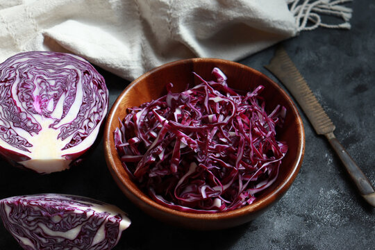 Shredded red cabbage in a wooden bowl.