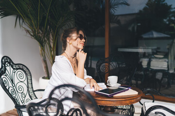 Freelancer woman smiling to herself, tablet open, coffee in reach. Captures peaceful joy and tech...