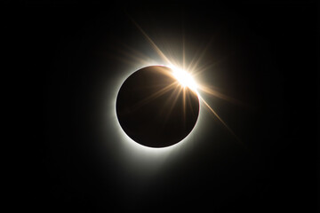 A stunning total solar eclipse. The sun's corona is vividly glowing in the sky. The silhouettes of the moon and sun adeal for astronomy, nature, and dramatic sky-themed background