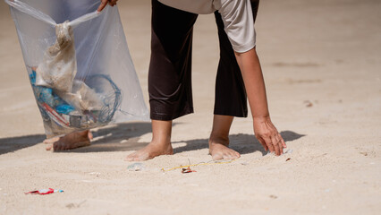 A group of older people are picking up trash on the beach to help keep nature clean and beautiful.