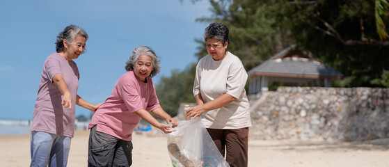 A group of older people are picking up trash on the beach to help keep nature clean and beautiful.