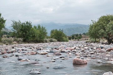 Rocky mountain Turgen river with trees and overcast sky, Kazakhstan.