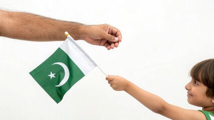 Passing on patriotism A child receives the flag of Pakistan from their father symbolising heritage