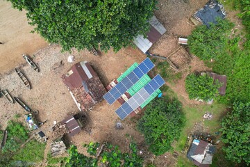 Aerial view of photovoltaic cells, absorbing solar energy on top of a  house in the middle of beach © Wirestock