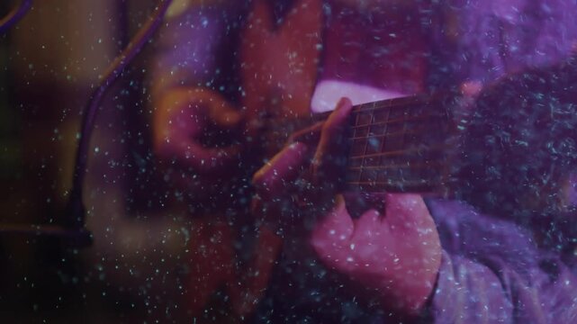Camera panning over guitar neck, guitarist plucking and strumming chords in purple-haze particles