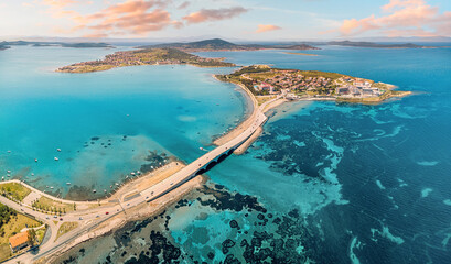 Panoramic aerial view of Cunda Island and Ayvalik, Turkiye, connected by a bridge, showcasing the vibrant turquoise Aegean Sea and coastal town © EdNurg