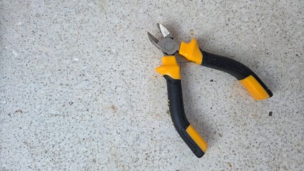 Diagonal pliers on concrete surface for diy tools and maintenance projects. Horizontal banner. Copy space. Wire cutters or diagonal cutting pliers