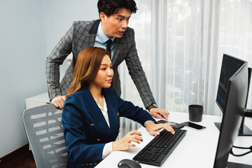 Asian business partners pointing to profit highest dynamic stock exchange data on computer screen value rate online website program. Investor showing financial on real time at modern office. Infobahn.