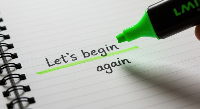 Hand highlighting motivational phrase "Let's begin again" in notebook  