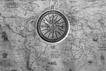 Classic round compass on background of old vintage map of world
