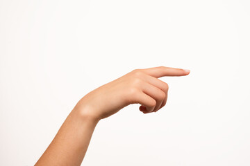 A woman's hand with fair skin is shown pointing with the index finger, isolated on a white...