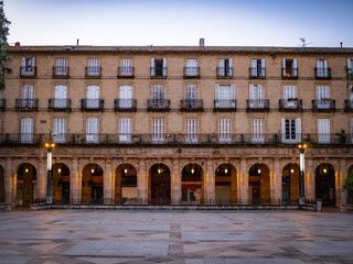 Obraz premium Plaza Nueva in Bilbao’s Casco Viejo at dawn, bathed in soft morning light, reveals neoclassical arches and balconies—an elegant and historic gem for early explorers in Spain.