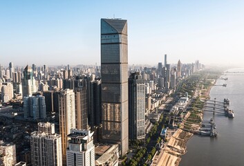 Modern city skyline with skyscraper and riverbank.