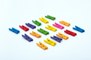 Colorful clothespins lined up on a white background.