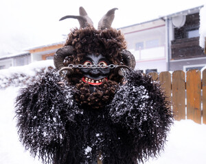 Traditional winter festival with performer in elaborate costume celebrating in snowy village