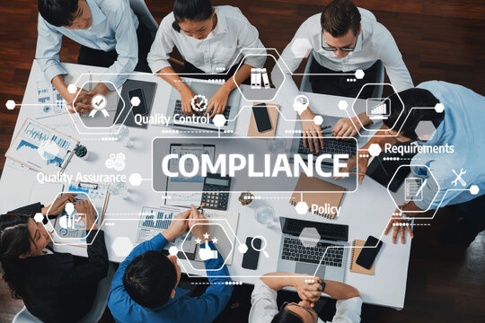 Fototapeta Compliance Training Workshop with Diverse Professionals Engaging Over Laptops and Documents in a Modern Office Setting. Amity