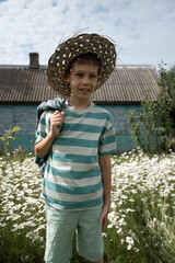 a boy in a straw hat threw his shirt over his shoulder
