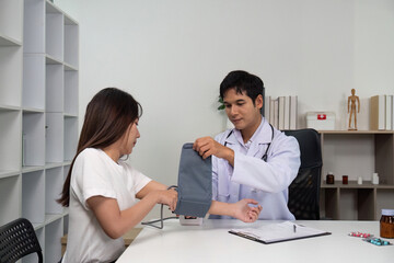 Blood Pressure Check. Doctor measuring blood pressure of a young woman.