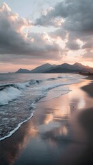 Naklejka premium Waves crashing on sandy beach at sunset, with golden light reflecting off the water and dramatic clouds adding depth to the coastal scenery