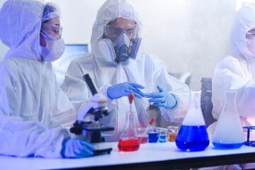 Fototapeta premium A team of scientists in hazmat suits works on a vaccine in a high-security biocontainment lab. Concept for pandemic response, virology, and medical research.
