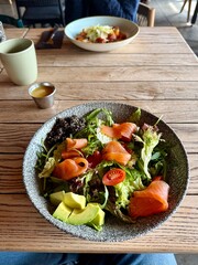 Healthy Salmon and Avocado Salad Served at Cozy Restaurant Table
