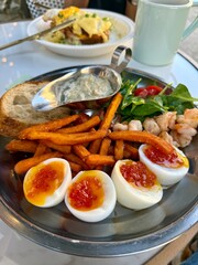 Gourmet Brunch Plate with Soft-Boiled Eggs, Sweet Potato Fries and Sauce
