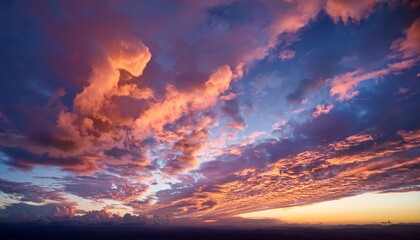 stunning dramatic sunset sky with towering fluffy pink and orange clouds above the horizon