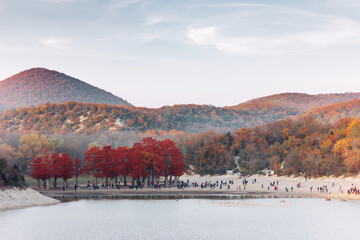 Beautiful landscape on Sukko lake with view of red cypress and mountains with tourists, autumn...