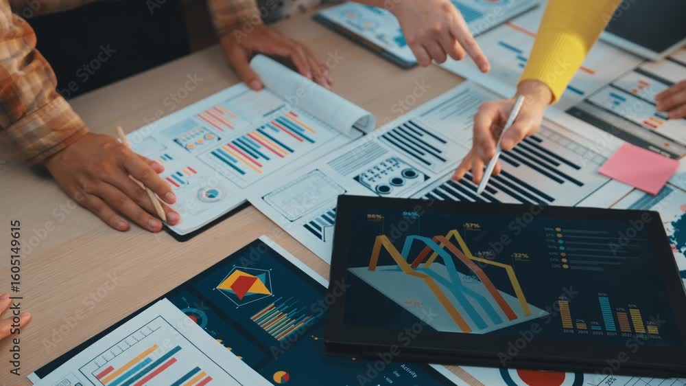 Poster a team engages in a collaborative meeting, analyzing charts and data on a conference table. hands po