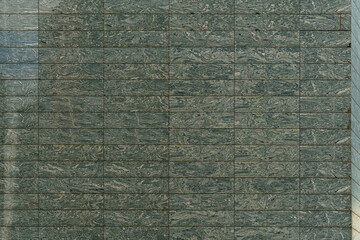 Green marble tiles with bold veining form an elegant wall surface. The natural stone texture brings a sense of luxury and depth to the interior.