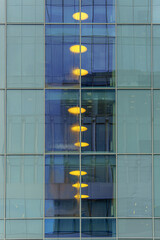 Reflections of street lights in glass windows create a multilayered visual structure. Light and geometry enhance the sense of depth and urban rhythm.