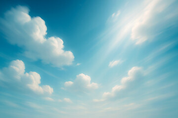 Obraz premium Fluffy white clouds in vibrant blue sky with sun rays peaceful, dreamy atmosphere for outdoor and nature background uses