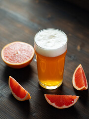 Refreshing citrus grapefruit beer in a glass on a wooden table