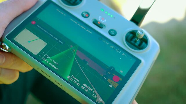 Activating smart return home after aerial filming on drone controller close-up. Using intelligent positioning system for safe navigation. Executing autonomous flight path with precise route guidance