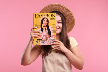 Woman with fashion magazine on pink background