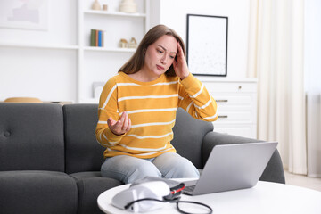 Sick woman having online consultation with doctor via laptop at home
