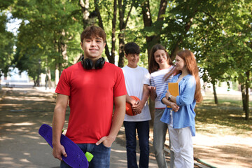 Group of teenagers walking together in park, selective focus