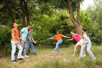 Obraz premium Team building. Group of happy people playing spider web game outdoors