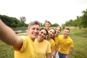 Team building. Group of happy people taking selfie outdoors