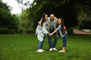 Happy family posing in park, space for text