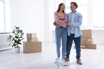Happy young couple dancing and cardboard boxes at home, low angle view. Moving day