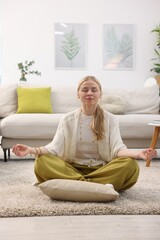 Feng shui. Young woman meditating on floor at home