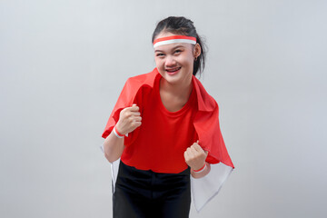 Smiling young woman wearing red and white proudly wraps herself in the Indonesian flag, expressing...