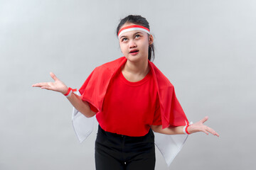 Indonesian woman in red clothes and flag expressing sarcasm or boredom with a shrug, rolling eyes...