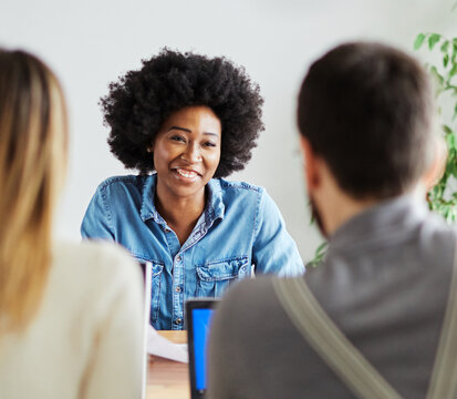 Portrait of a happy young businesswoman during a meeting or job interview in front of members of the management in the office