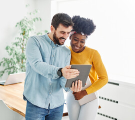 Portrait of young happycouple with tablet and laptop, using modern technology havinmg fun, startup business meeting of young businesspeople in office