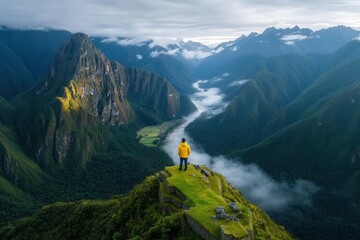 Lost world explorer stands atop Machu Picchu ruins admiring the Andes morning mists