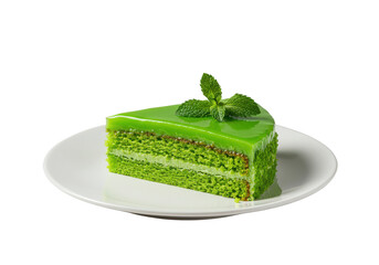 A slice of green cake with glaze and mint leaves on a white plate against a plain setting on transparent background