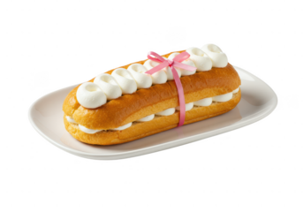 Delicious pastry filled with cream and tied with a pink ribbon on a white plate isolated on transparent background